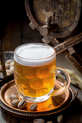 Light beer in a glass on a table in composition with accessories on an old background