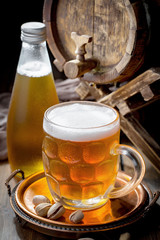 Light beer in a glass on a table in composition with accessories on an old background