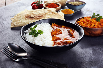 Chicken tikka masala spicy curry meat food in pot with rice and naan bread. indian food on table
