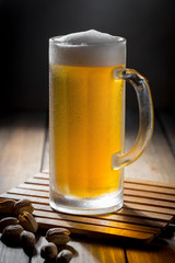 Light beer in a glass on a table in composition with accessories on an old background