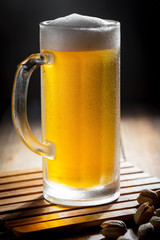 Light beer in a glass on a table in composition with accessories on an old background