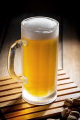 Light beer in a glass on a table in composition with accessories on an old background