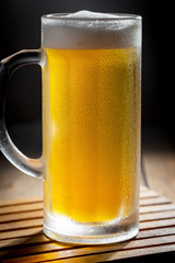 Light beer in a glass, on an old background. 