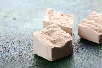 Dry yeast crumbled and yeast block for baking on background