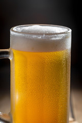 Light beer in a glass on a table in composition with accessories on an old background