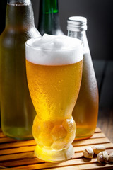 Light beer in a glass on a table in composition with accessories on an old background