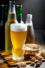 Light frothing beer in a glass, on an old background.