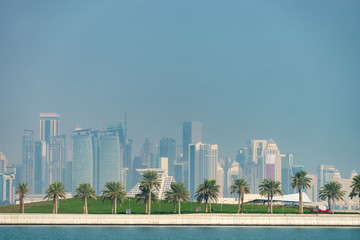 Fototapeta na wymiar Panoramic view of modern skyline of Doha with Palms foreground. Concept of healthy environment