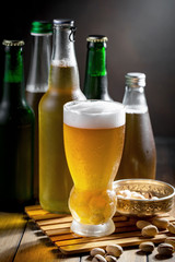 Light beer in a glass on a table in composition with accessories on an old background
