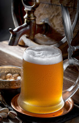 Light beer in a glass, on an old background.