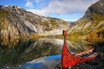 Beautiful mountain moraine lake viking ship on shore Norway