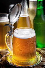 Light beer in a glass on a table in composition with accessories on an old background