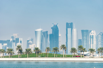 Obraz na płótnie Canvas Panoramic view of modern skyline of Doha with Palms foreground. Concept of healthy environment