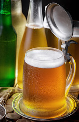 Light beer in a glass on a table in composition with accessories on an old background