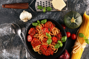 Tasty appetizing classic italian spaghetti pasta with tomato sauce, cheese parmesan and basil and ingredients