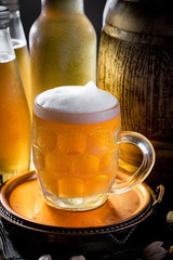 Light beer in a glass on a table in composition with accessories on an old background