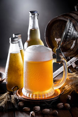 Light beer in a glass on a table in composition with accessories on an old background