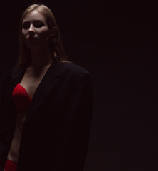 dramatic portrait of a sexy girl in red underwear in a dark room under a dim lamp