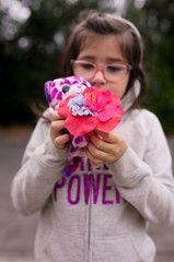 A girl is smelling flowers while out on a nature walk.