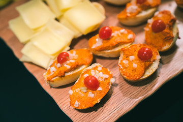 Vegetarian Finger Food with toast, orange hummus, cherry tomatoes and chopped onions