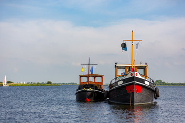 2 old tugboats at anchor on lake 't Joppe in the Netherlands.