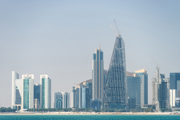 Fototapeta na wymiar Panoramic view of modern skyline of Doha through the blue water. Concept of wealth and luxury