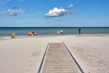 Tourist taking photos of his family at a sandy beach.