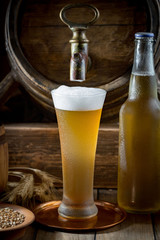 Light beer in a glass on a table in composition with accessories on an old background