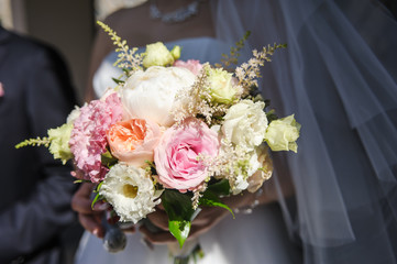 Obraz na płótnie Canvas Delicate bouquet of pink and white flowers in the hands of the bride. Unusual wedding stylish bouquet with pink and white flowers, wedding dress, details