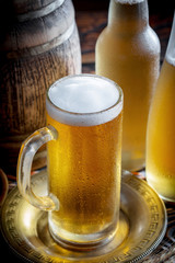 Light frothing beer in a glass, on an old background.