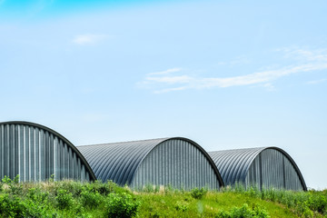 Large hangars made of galvanized corrugated a sheet iron.