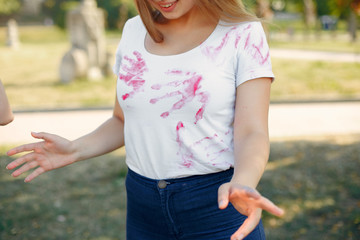 Friends with a holi paints. People in a summer park. Girls have fun.