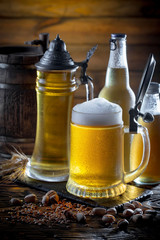 Light beer in a glass on a table in composition with accessories on an old background