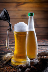 Light beer in a glass on a table in composition with accessories on an old background