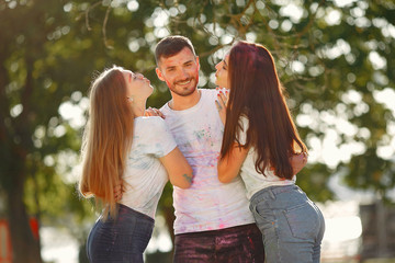 Fototapeta premium Friends with a holi paints. People in a summer park. Students have fun.