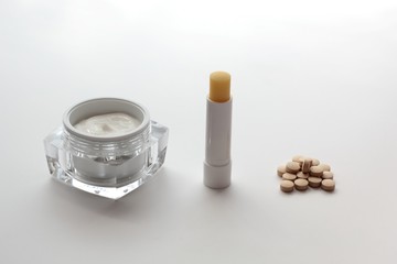 Set of items relieving side effects of isetretinoin treatment: moistuiser, lip balm and milk thistle.
