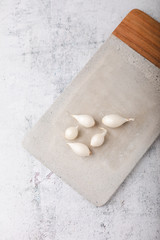 Whole Pearl Onions on Cement Cutting Board on Cement Countertop