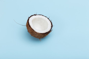 Fresh half natural coconut on blue background.