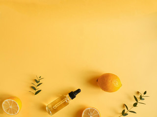 bright flatlay composition with oil, citrus and eucalyptus. on yellow background. Concept beauty natural vitamin cosmetic product, skin care, copyspace, top view