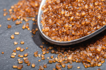 Macro view of metal spoon with ground brown sugar