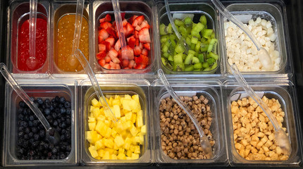 Kiwi fruit, strawberry, blueberry, mango garnishes for frozen yogurt or yoghurt in toppings or garnishes tray