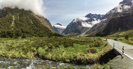 Green fields and snowcapped mountains in Fiordland National Park, New Zealand
