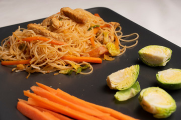 Tray with healthy vegetables cooking a wok with noodles, chicken and vegetable. Chinese food recipe.