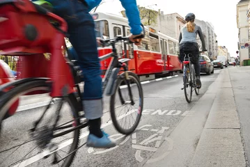 Fotobehang Gevaarlijke ontmoeting tussen fietsers, auto& 39 s en tram aan het einde van een gemarkeerd fietspad op drukke weg met veel verkeer in Wenen. © Timelynx