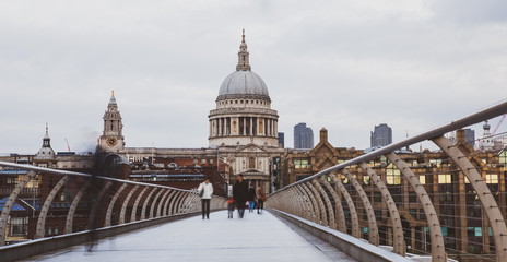 Fototapeta premium St Pauls Cathedral at Sunset in London UK. bridge in England walking on it. St Pauls Millennium Bridge London. Commuters & Tourists Walking along Millenium Bridge. Millennium Bridge St. Paul Cathedral