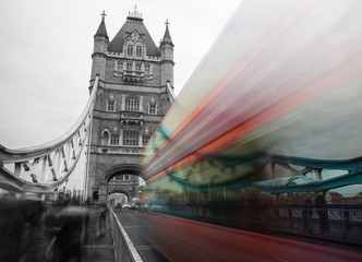 Fototapeta na wymiar Tower Bridge in London, UK in Twilight - Black and white motion blur of double decker bus on Tower Bridge London, UK. Red double-decker bus leaving light traces. London traffic blur on the bridge