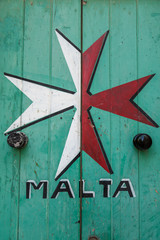 Maltese Cross painted onto an old, wooden, green door
