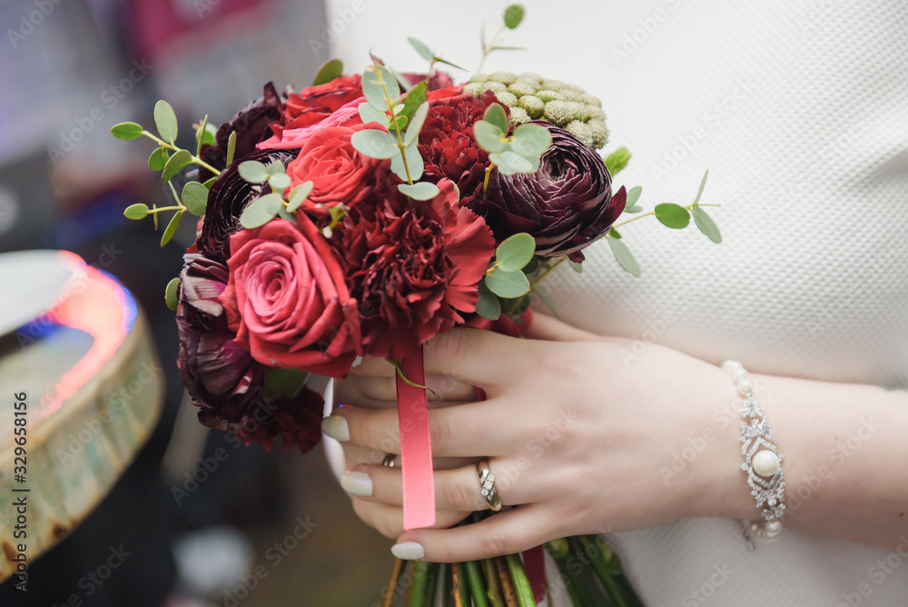 Wall mural Delicate bouquet of pink and white flowers in the hands of the bride. Unusual wedding stylish bouquet with red and purple flowers, wedding dress, details