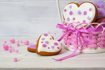 Gingerbread cookies in a wicker basket. Handmade multi-colored gingerbread cookies in the shape of a heart on a white table. Close-up