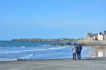 a couple of retired people who is watching the sea at Saint-Malo in brittany. France - obrazy, fototapety, plakaty